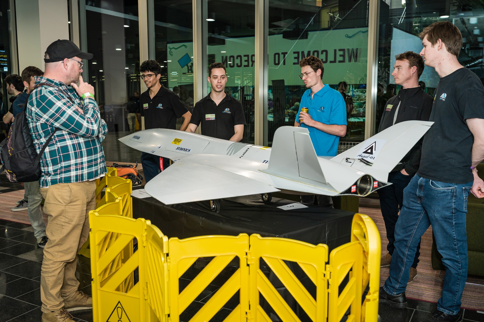 QUT CareCon 2022 students and industry talking around scale model fighter jet